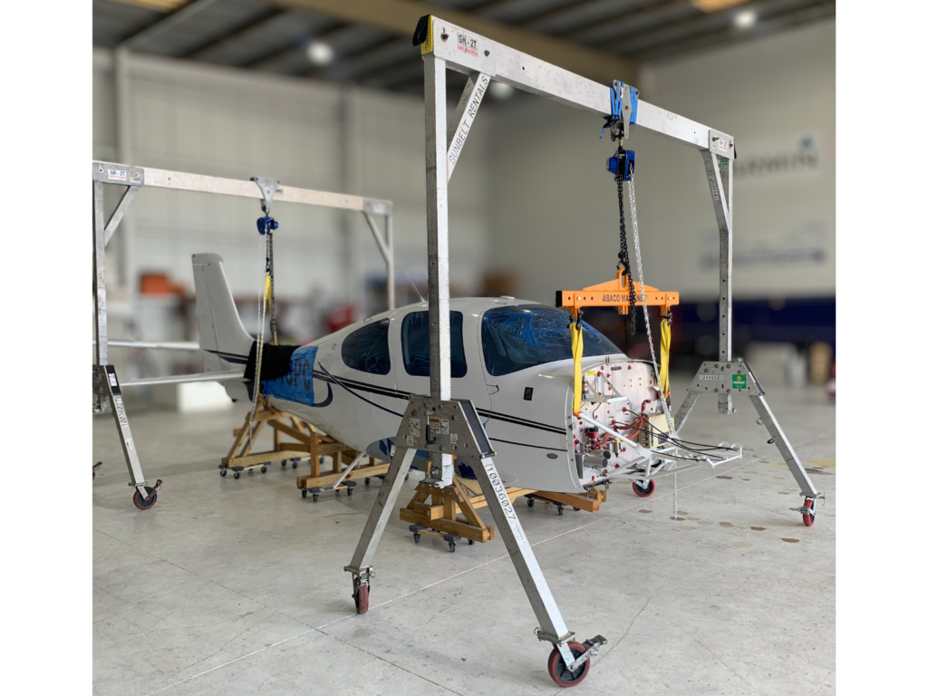Aircraft undergoing general maintenance inside hangar with professional lifting equipment at WakeWings Aerospace